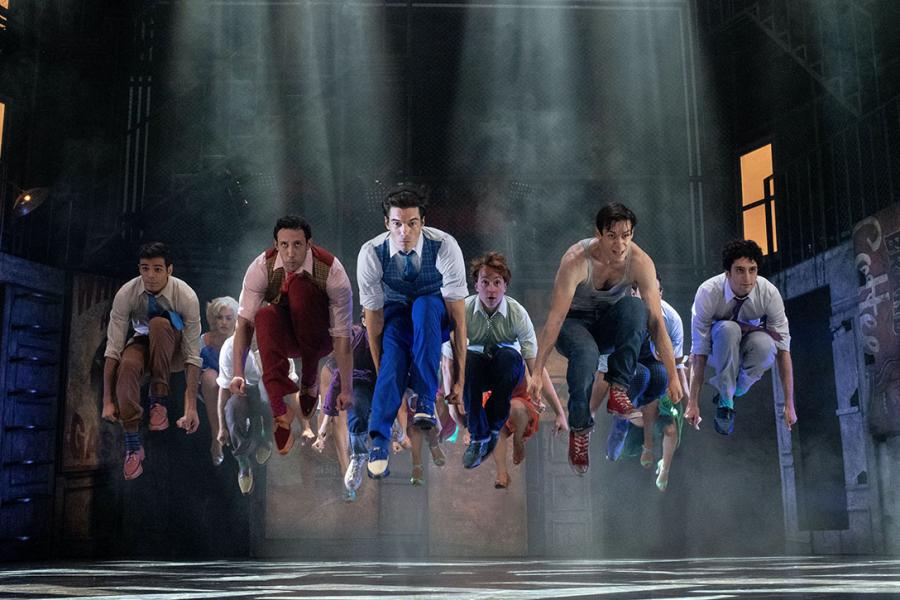 Leaping dancers pictured in a scene from the musical West Side Story.