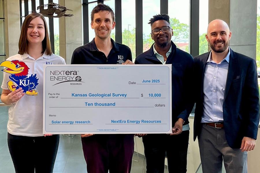 KGS staffers accept check from NextEra representatives.