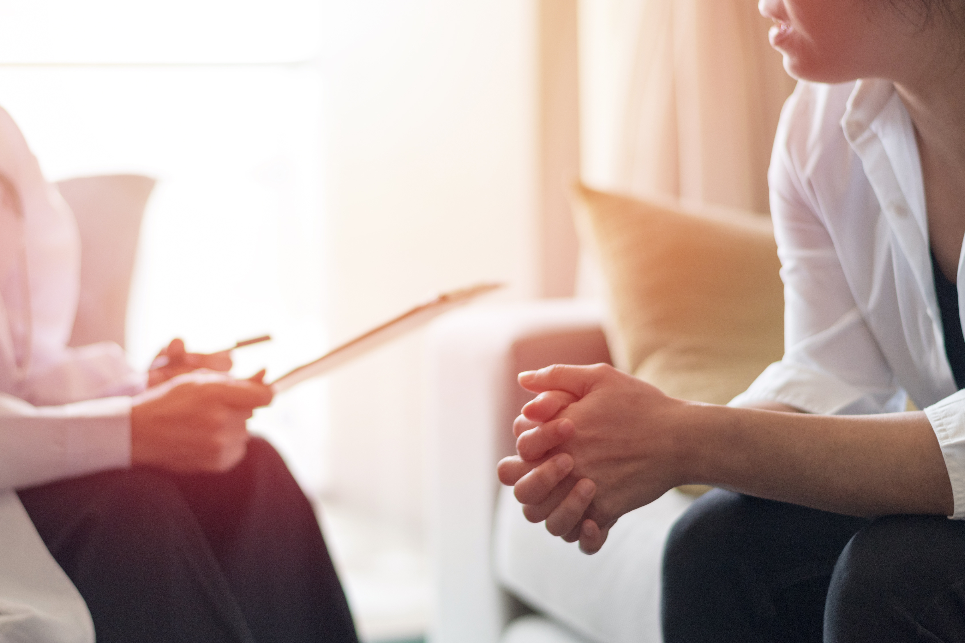 "A woman speaks to a health professional in a therapeutic setting"