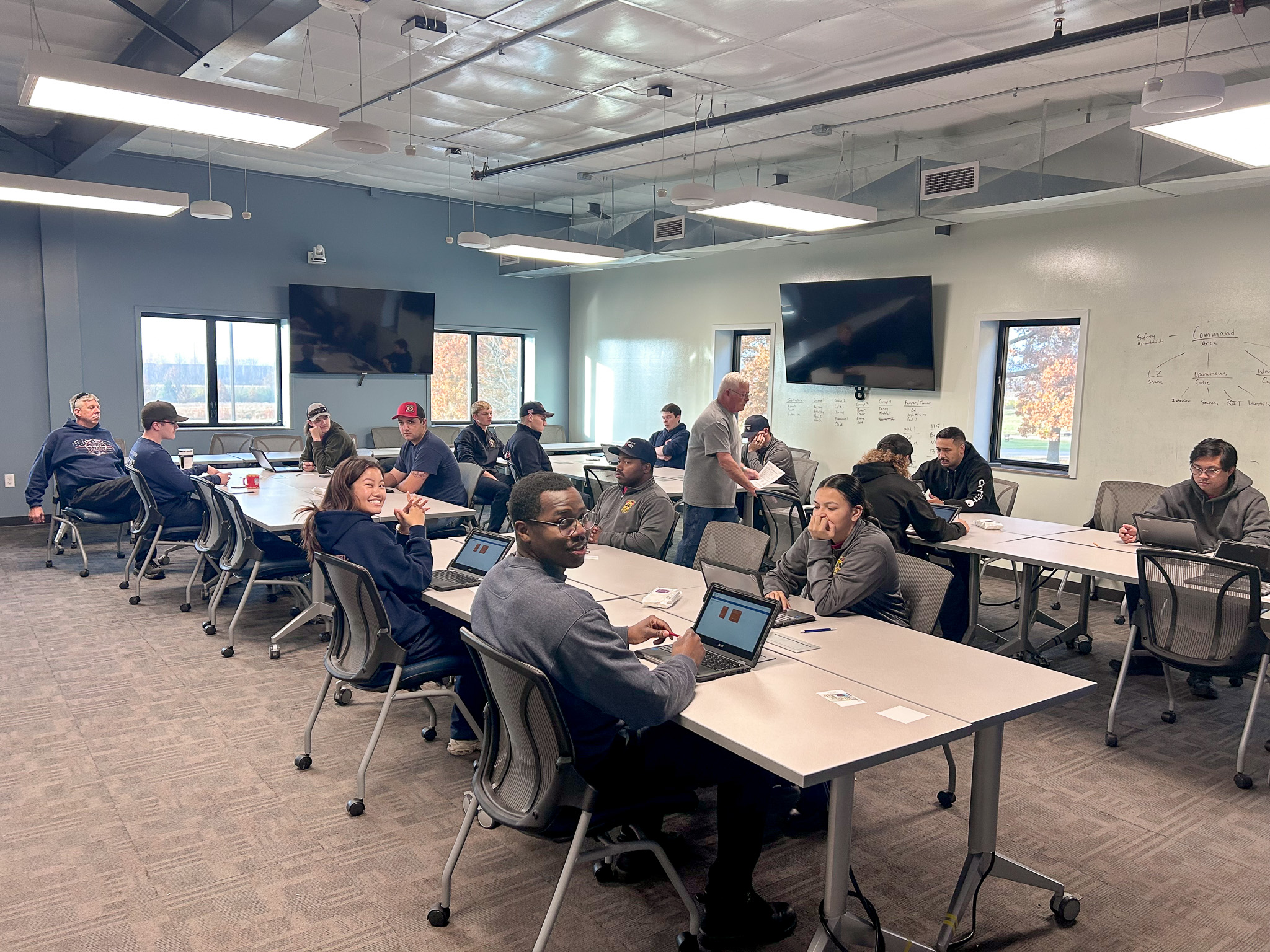 A room with KFRTI students sitting at tables using Chromebooks