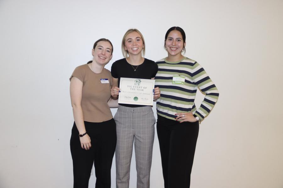 Student leaders Keri Barnes, Addison Murdock, and Ali Lopez with certificate for "Big Event of the Year" award presented to the University of Kansas