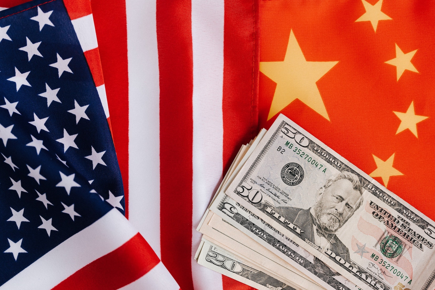 American flag, currency illustration overlapping Chinese flag, via Pexels.