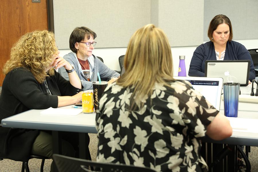 Teachers work at a table.