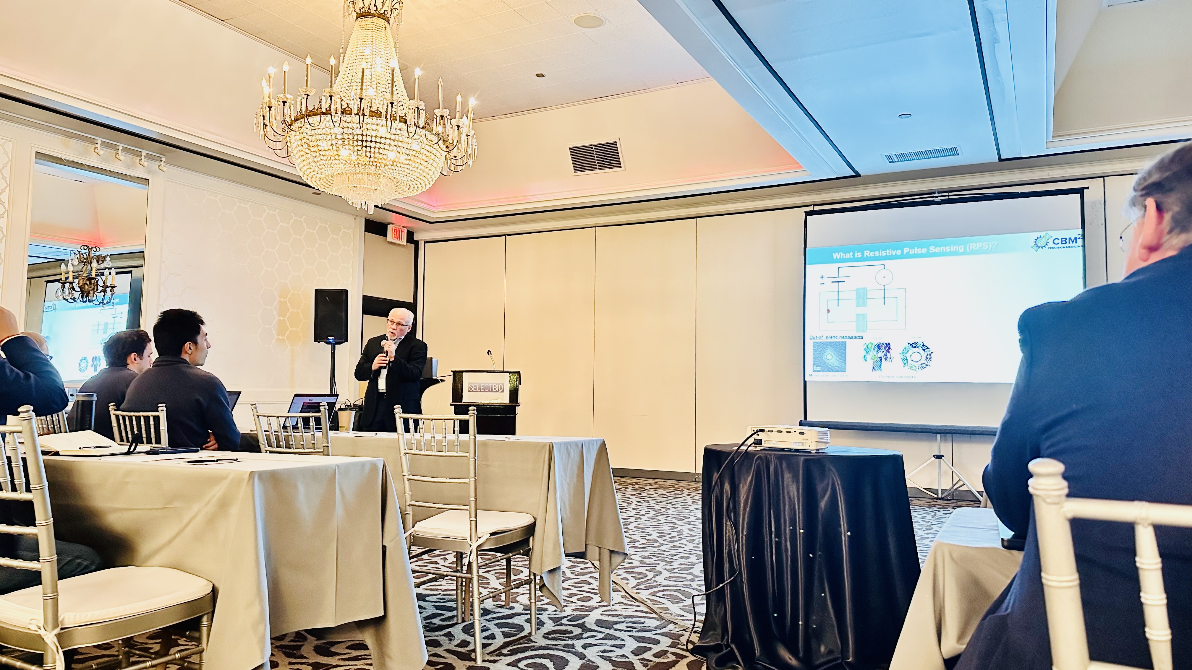 Dr. Soper stands before audience presenting slides to accompany his keynote address in a conference room at the SelectBio 2024 World Congress