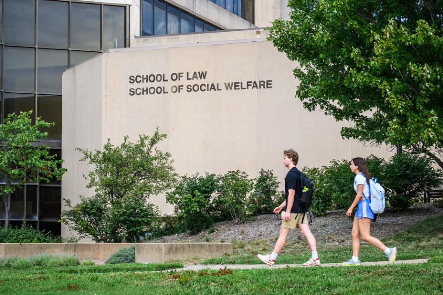 Students walk outside of Green Hall, home of the schools of social welfare and law, on the KU campus