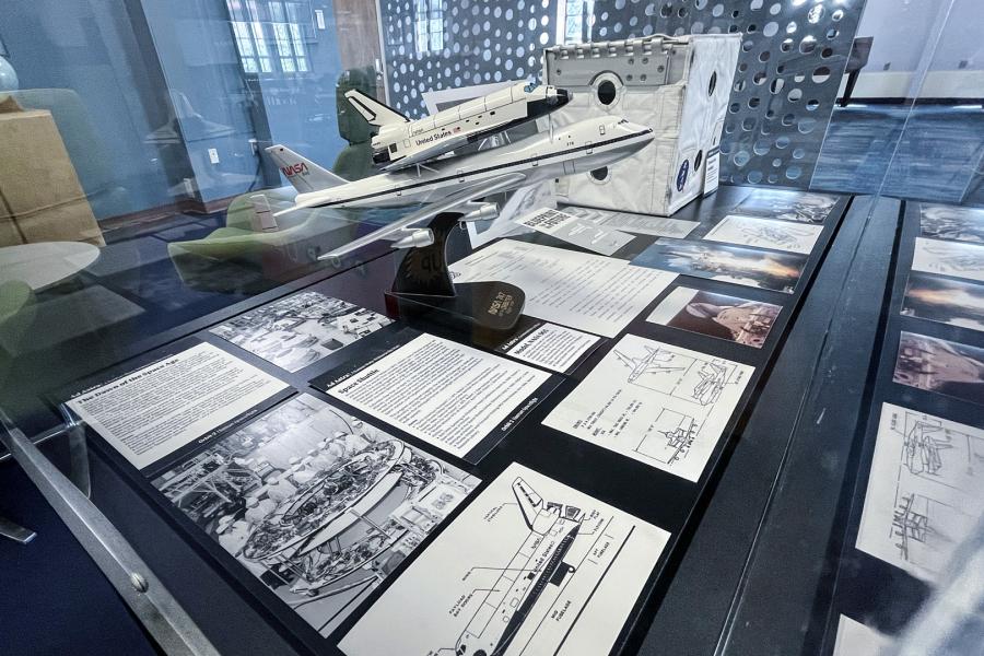 A close up view of one exhibit case in Watson Library's Haricombe Gallery reveals items related to the development of human spaceflight.