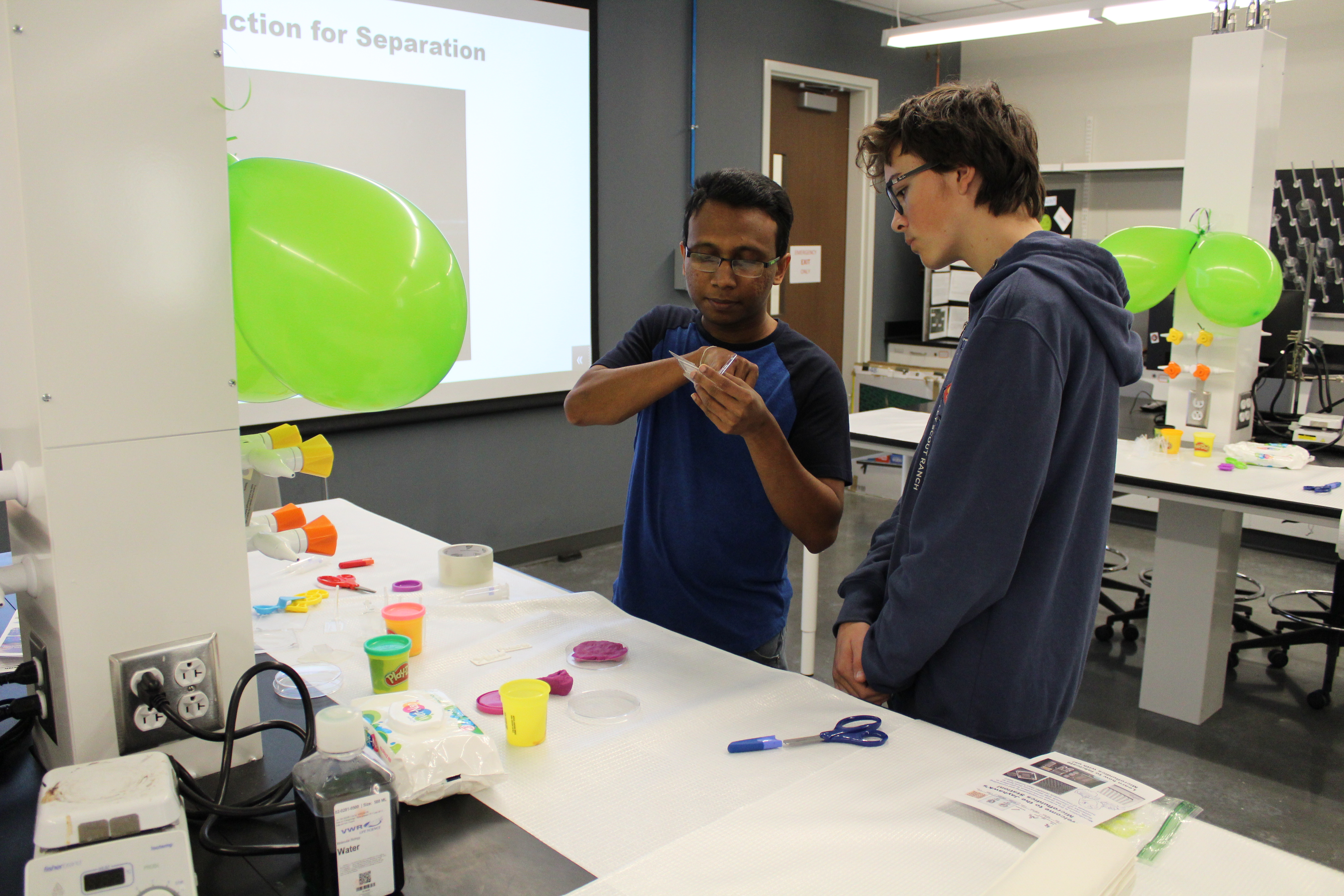 Two students actively engaged in a craft project.