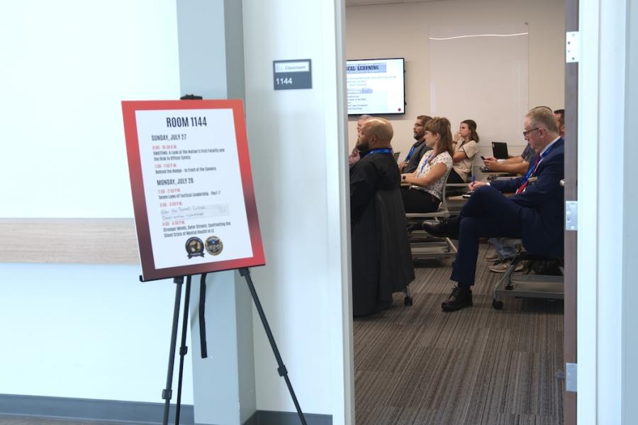 Attendees at a law enforcement conference seen through the door to a meeting room