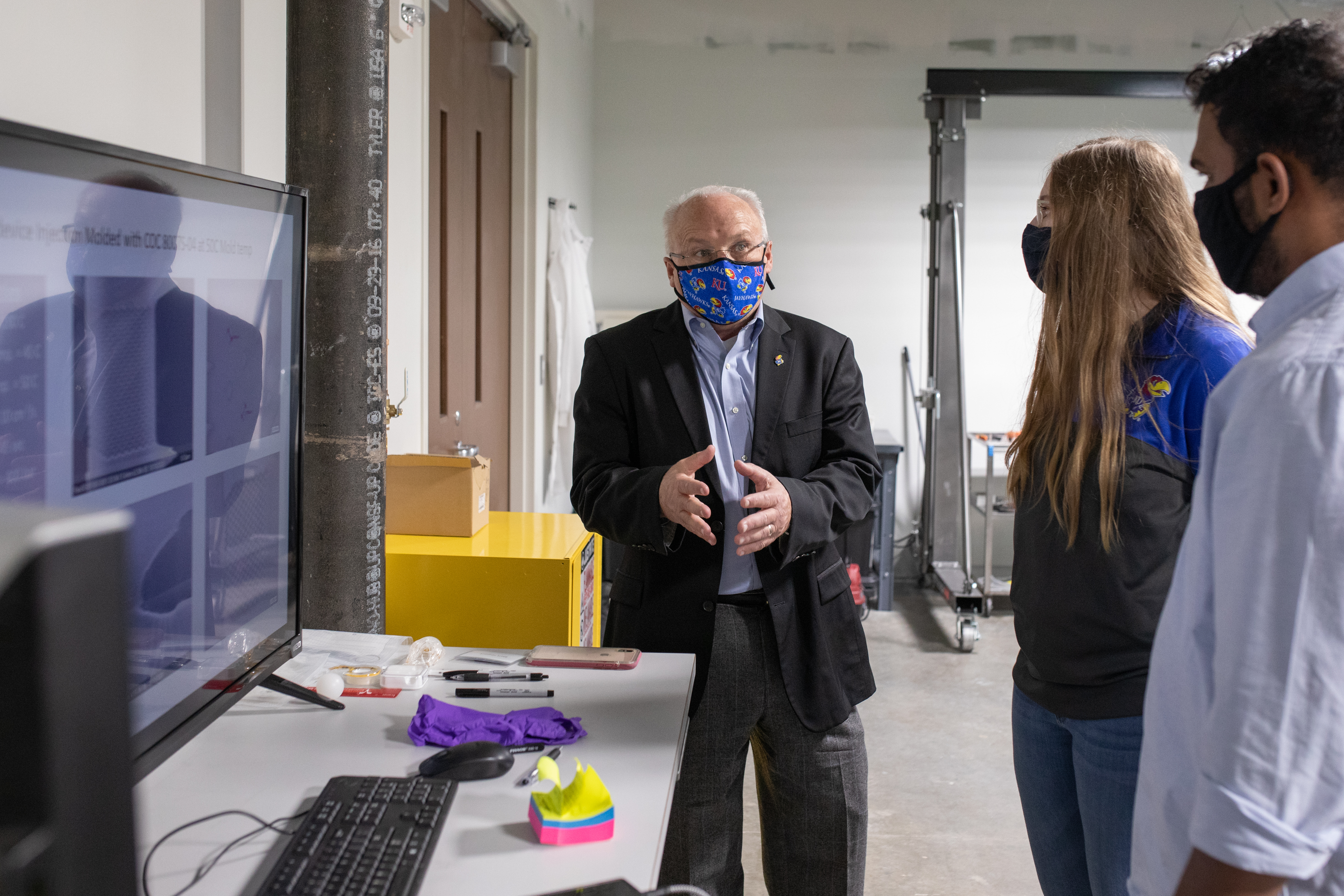 Foundation Distinguished Professor Steve Soper talks with students in a lab.