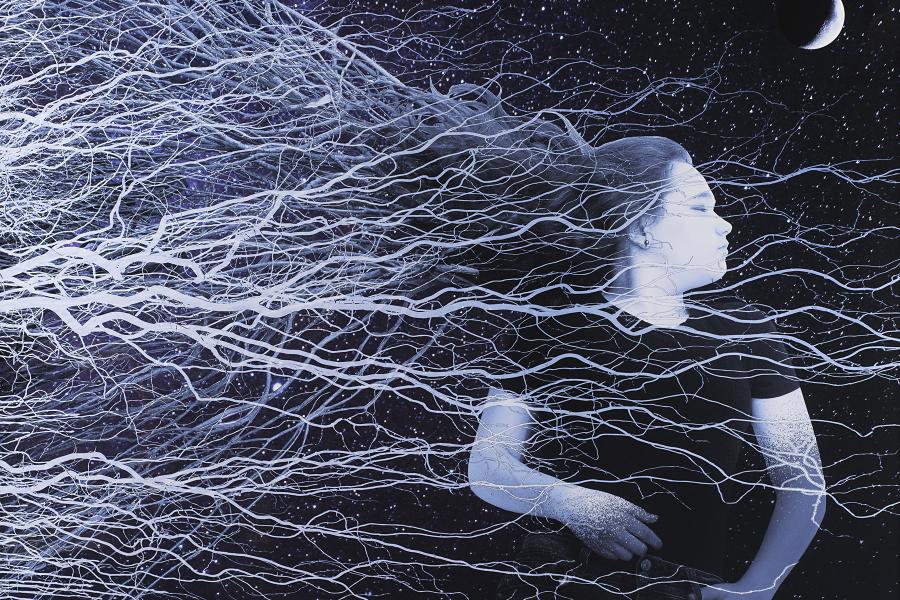 A young girl lies beneath a stary sky with her head turned to the side and her eyes closed; her hair stretches out behind her, mingling with what appear to be tree branches or roots