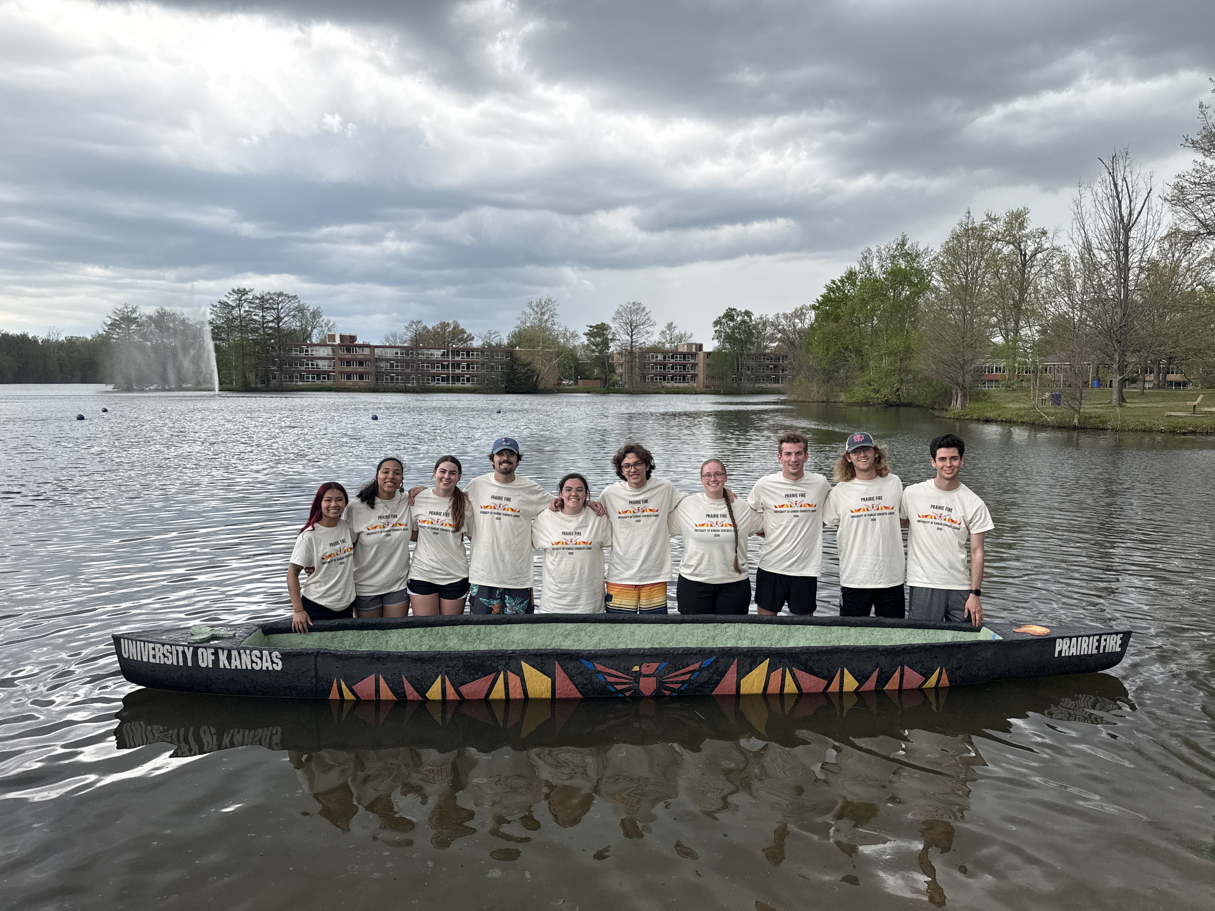 Students in concrete canoe on water