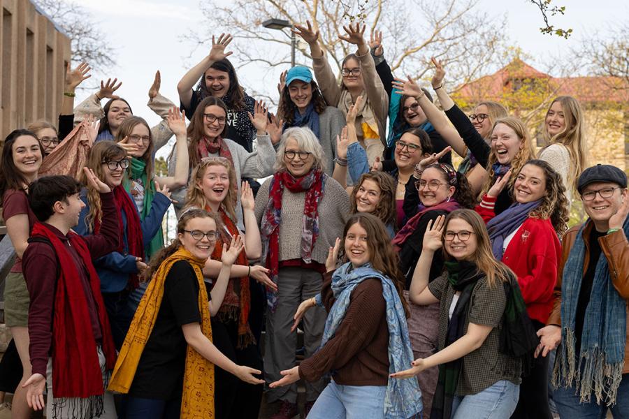 Group of students surround professor and pose