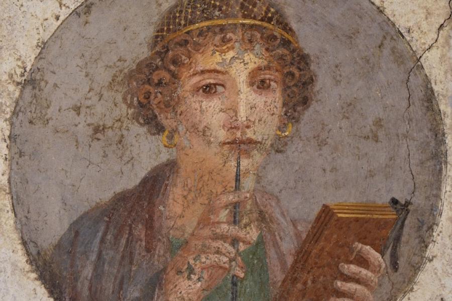 An ancient fresco shows a woman called Sappho holding writing implements.