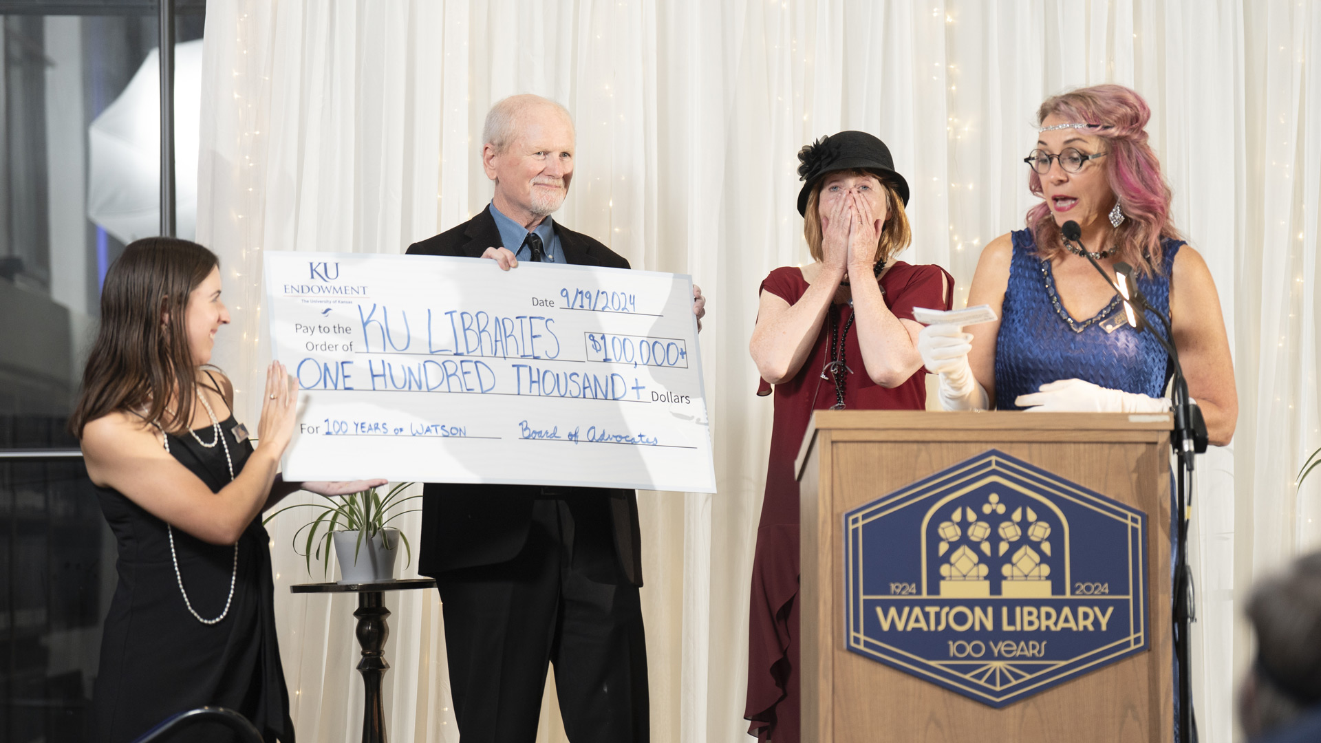 KU Libraries Dean Carol Smith is surprised with a $100,000 check from the Board of Advocates during "A Rhapsody in Jayhawk Blue" on Sept. 19.