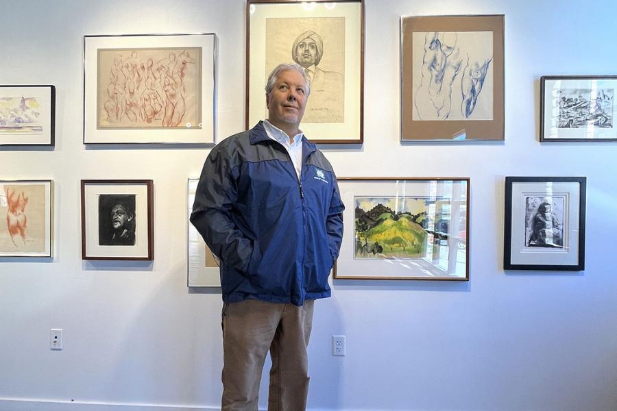 Man standing in front of gallery wall