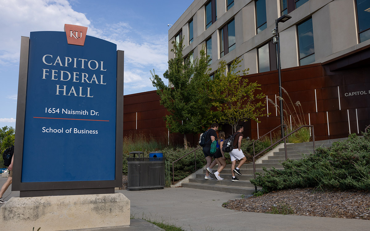 Students walk up the steps to Capitol Federal Hall, home to the University of Kansas School of Business.