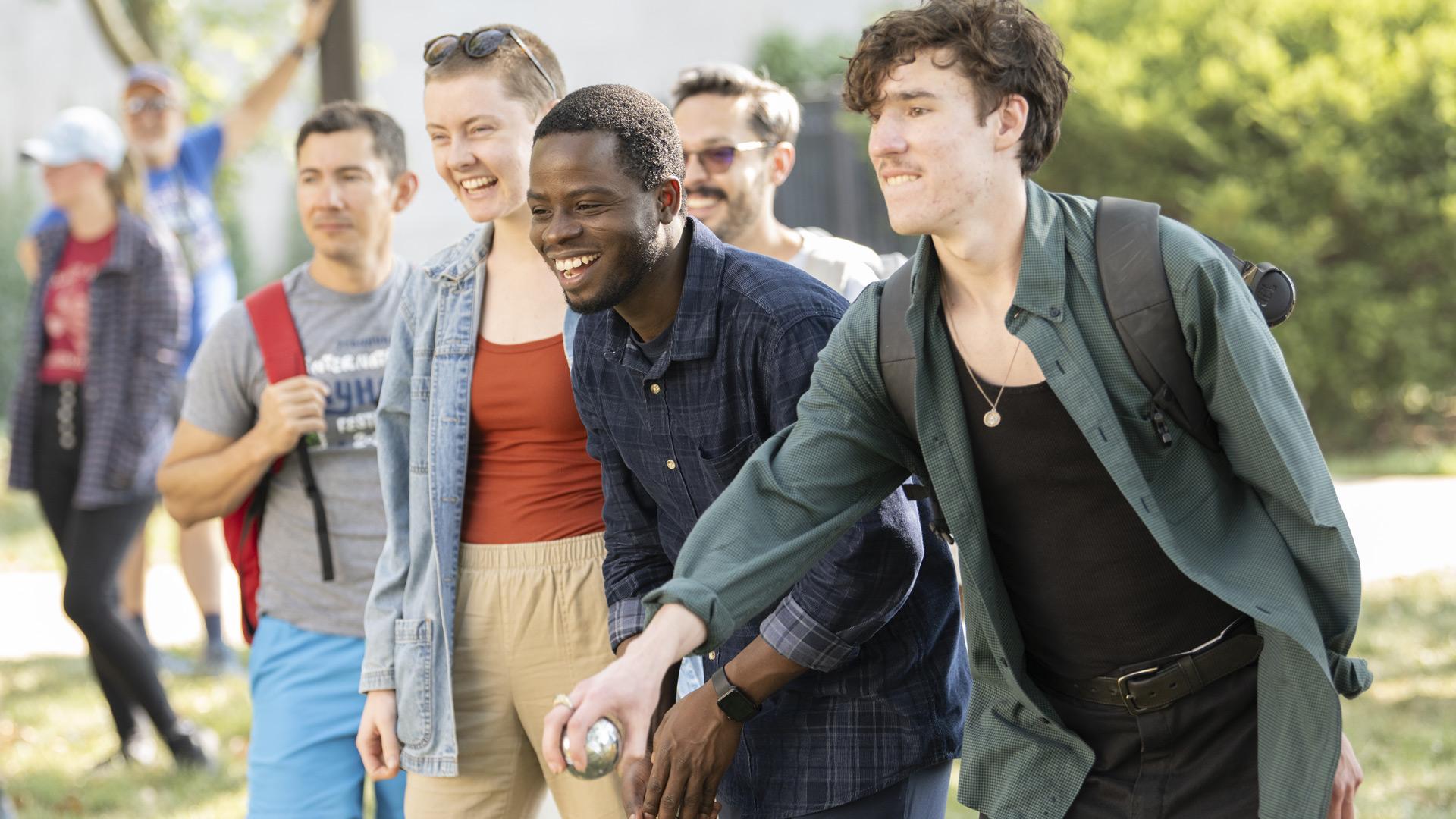 Students smile and play bocce on the front lawn of Watson Library