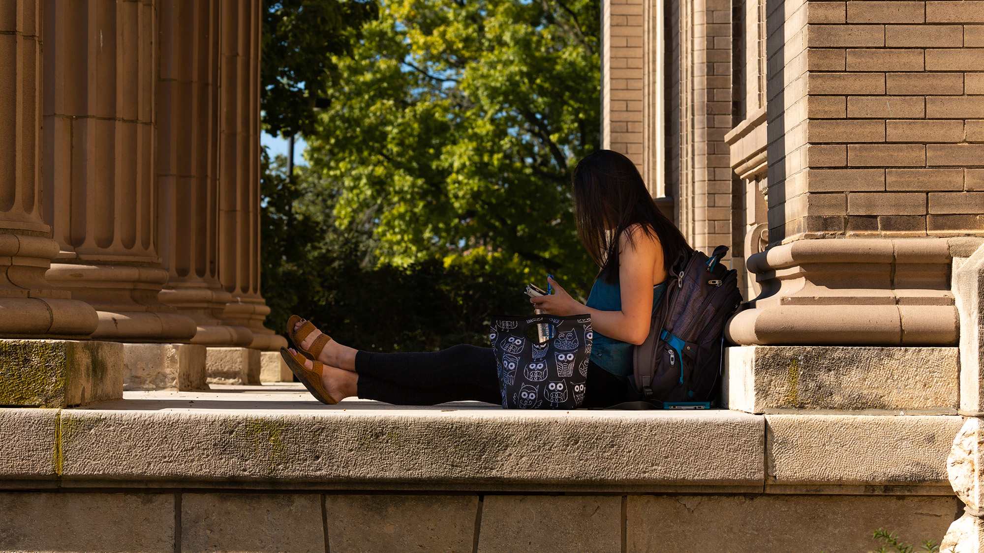 Student in front of Lippincott Hall, home of KU's Applied English Center.