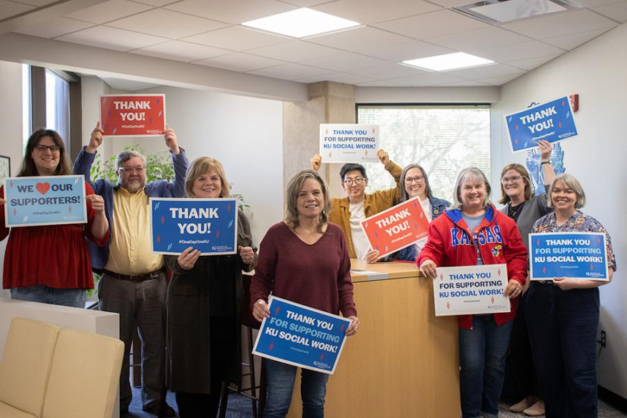 KU School of Social Welfare staff hold thank you signs for One Day One KU