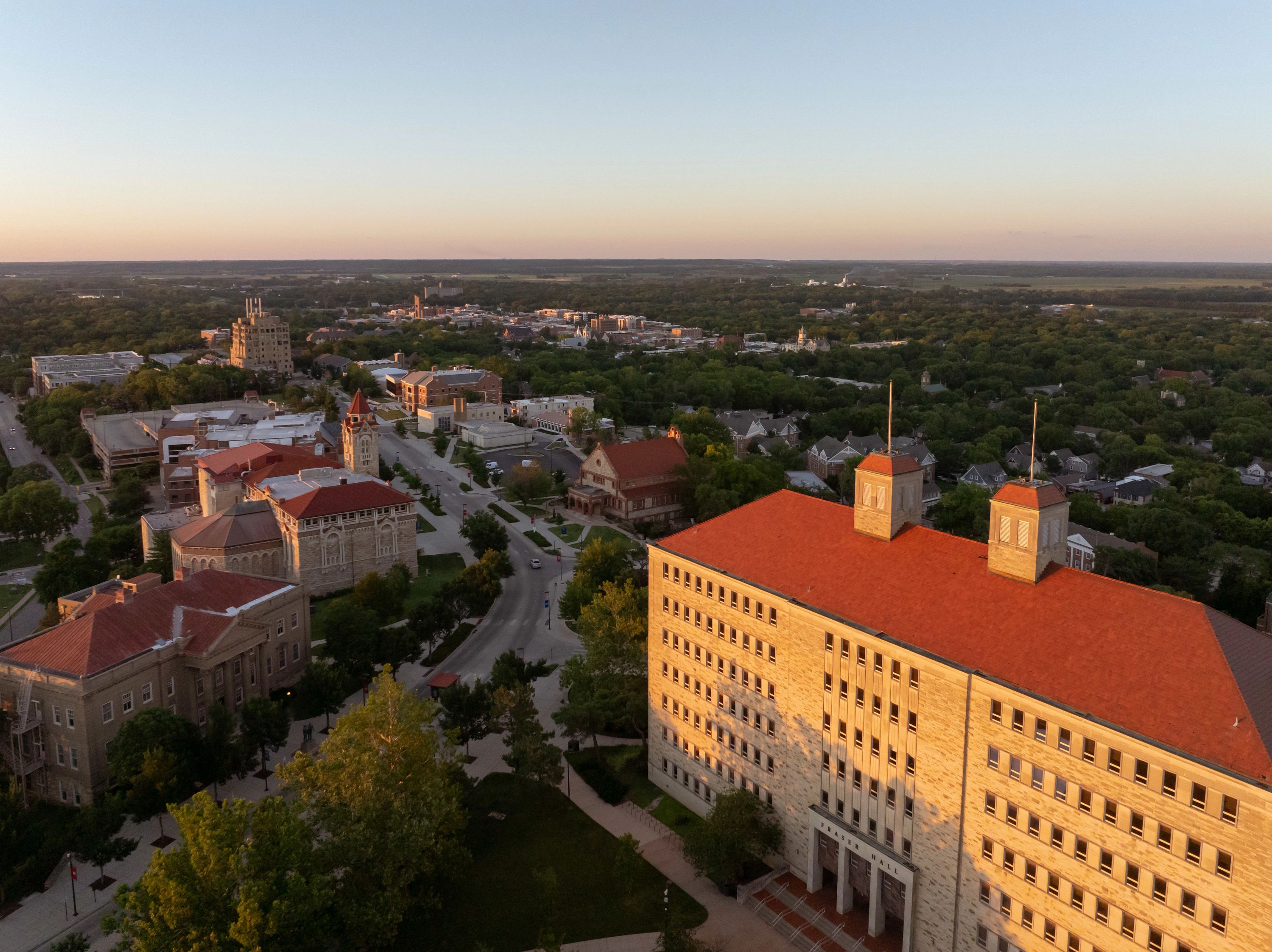 image of KU Lawrence campus with the sun rising on Fraser Hall in the foreground