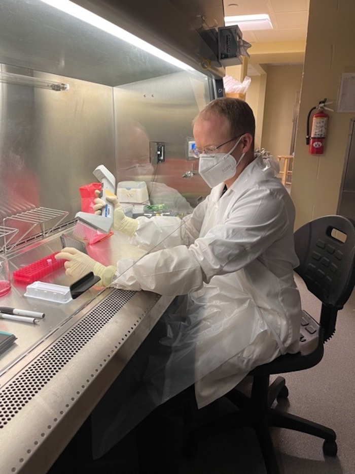 Peter McDonald transfers samples in the University of Kansas Infectious Disease Assay Development (IDAD) core facility