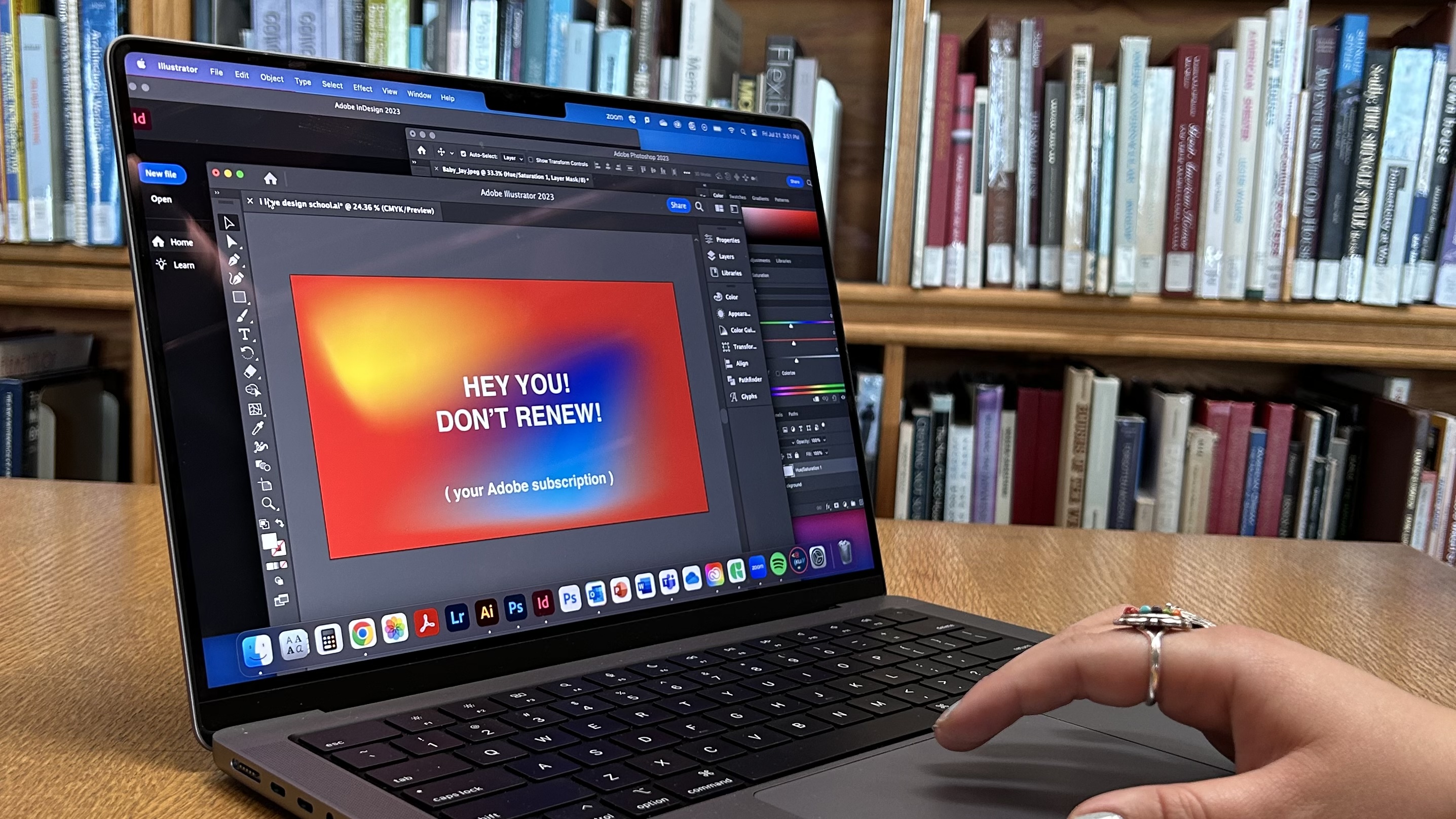 color photograph shows laptop computer on table in library space.