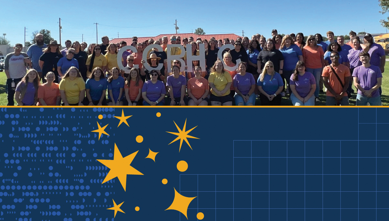 A large group photo of people holding large white letters that spell 'CCBHC' to celebrate Crawford County Mental Health's certification