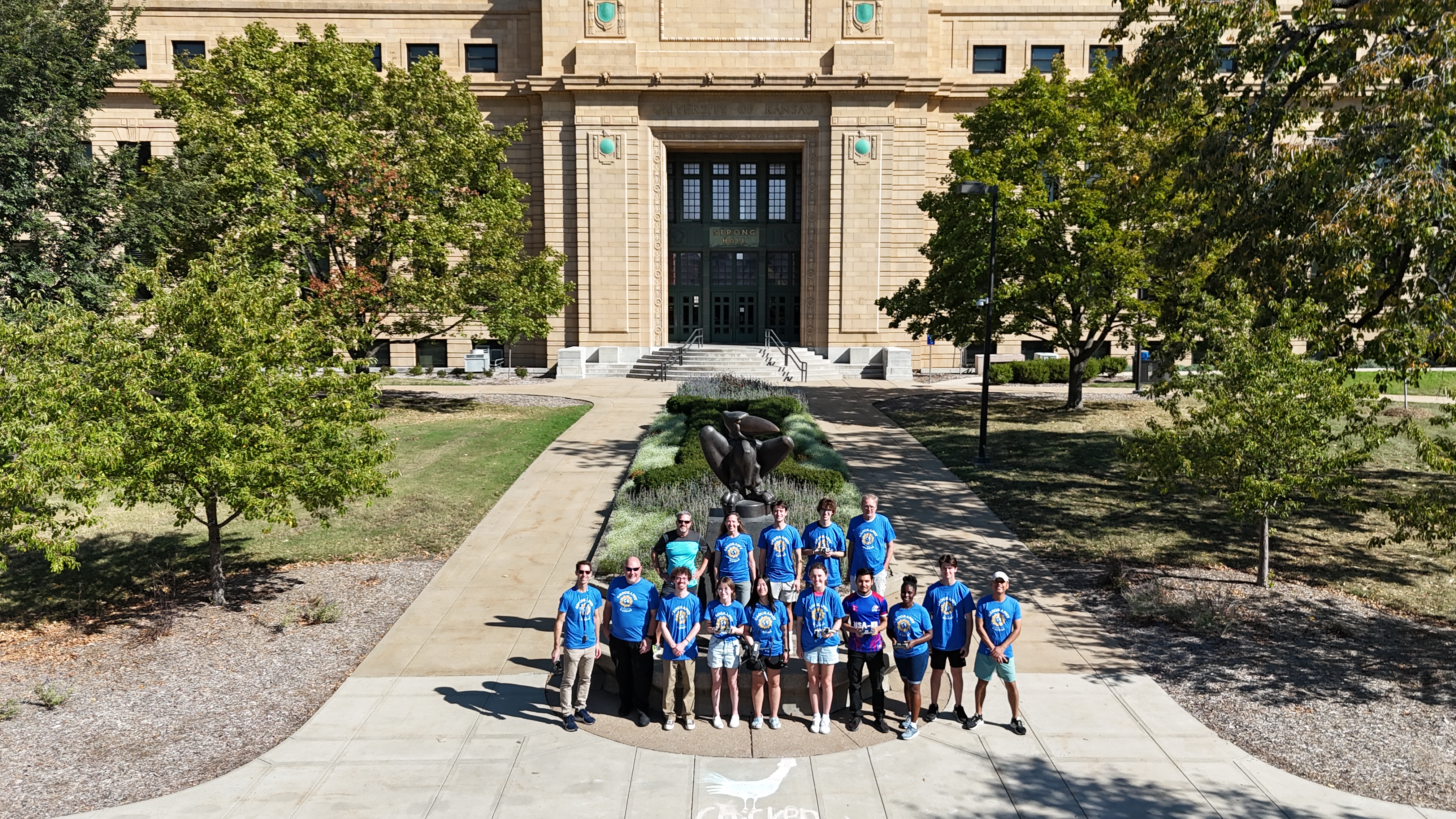 aerial drone photo of group of geography faculty and students wearing blue shirts. 