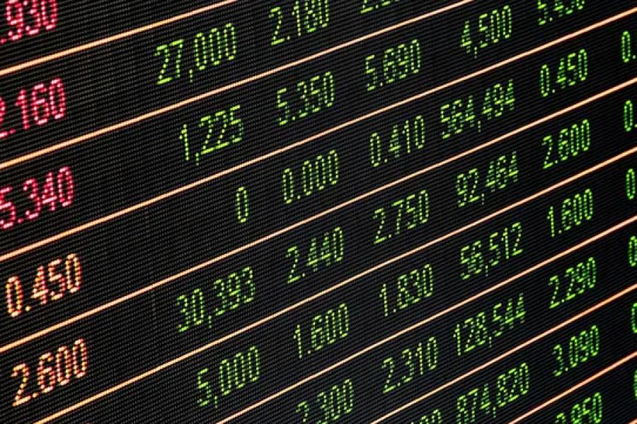 Close-up view of a stock market display board showing various stock prices in green and orange digital numbers.