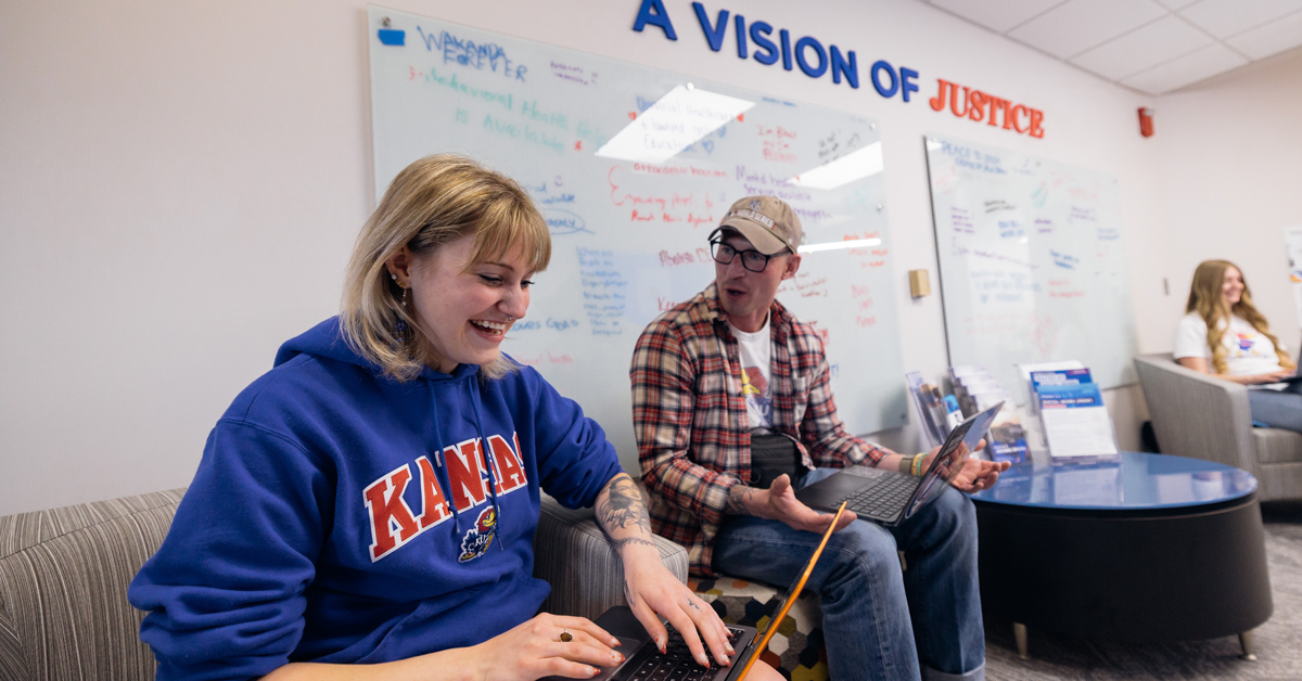 KU social work students talk and work on laptops in the new KU School of Social Welfare floor at Green Hall
