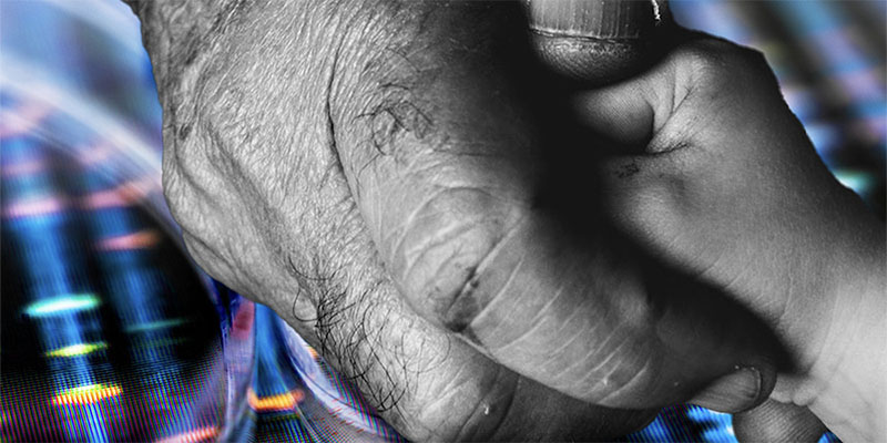 A black and white image of an older man's hand grasping a child's hand against a background of colorful lines from an image of DNA sequencing. 