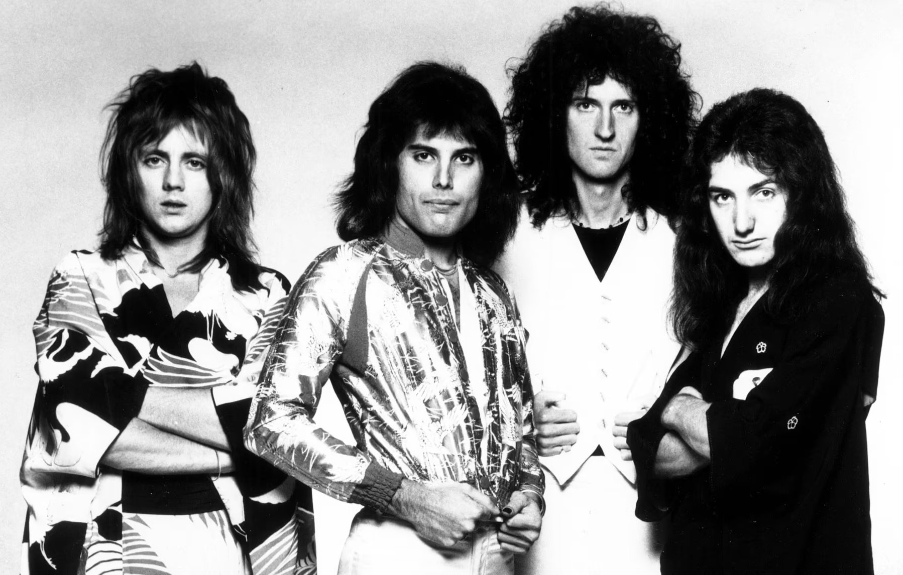 A black and white photo of members of the band Queen standing next to each other