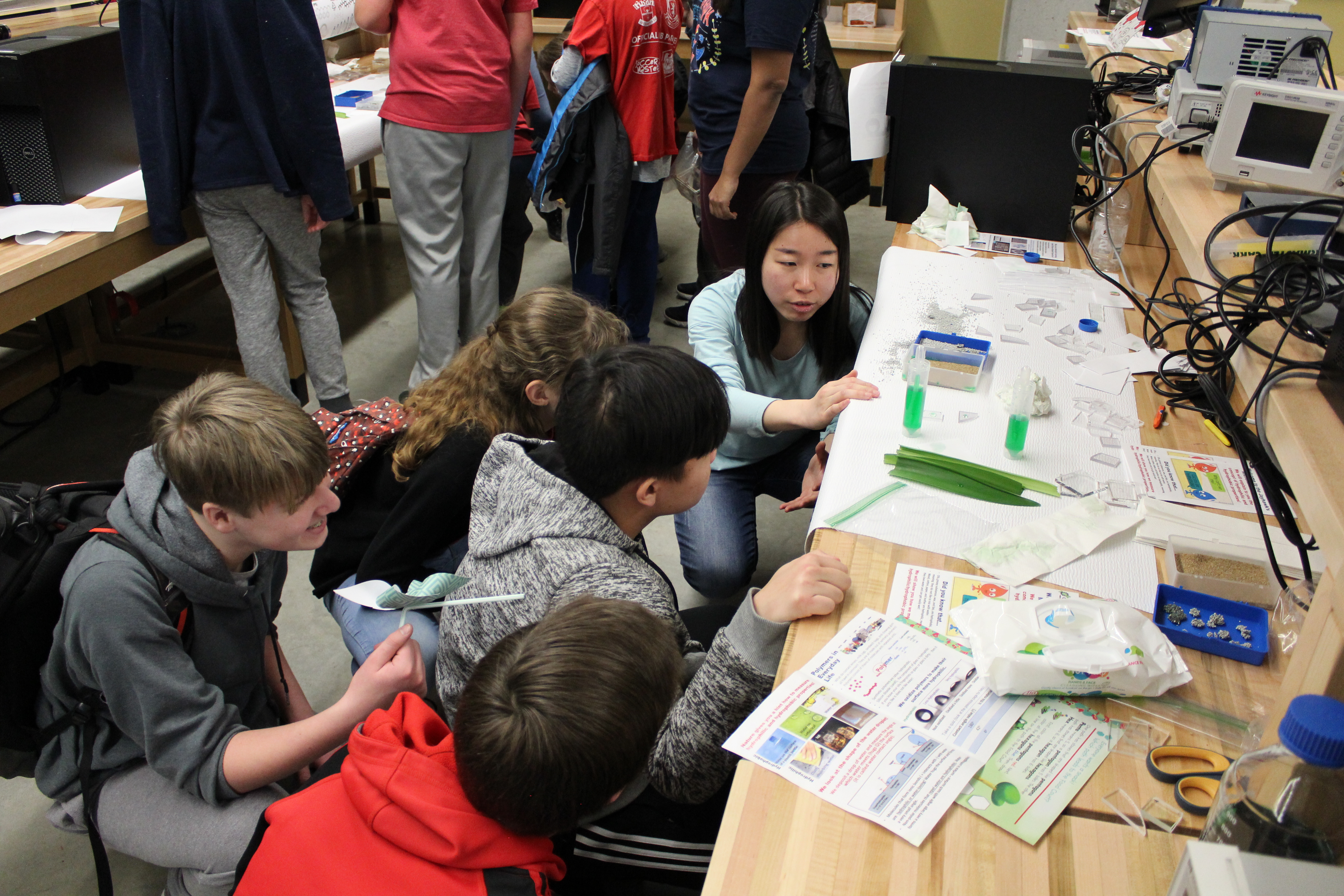 Group of students attentively examining chemistry glassware