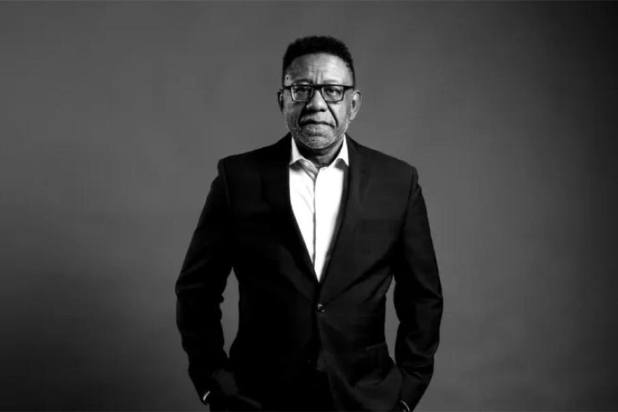 Randal Jelks stands with his hands in his pockets in a black and white portrait photo