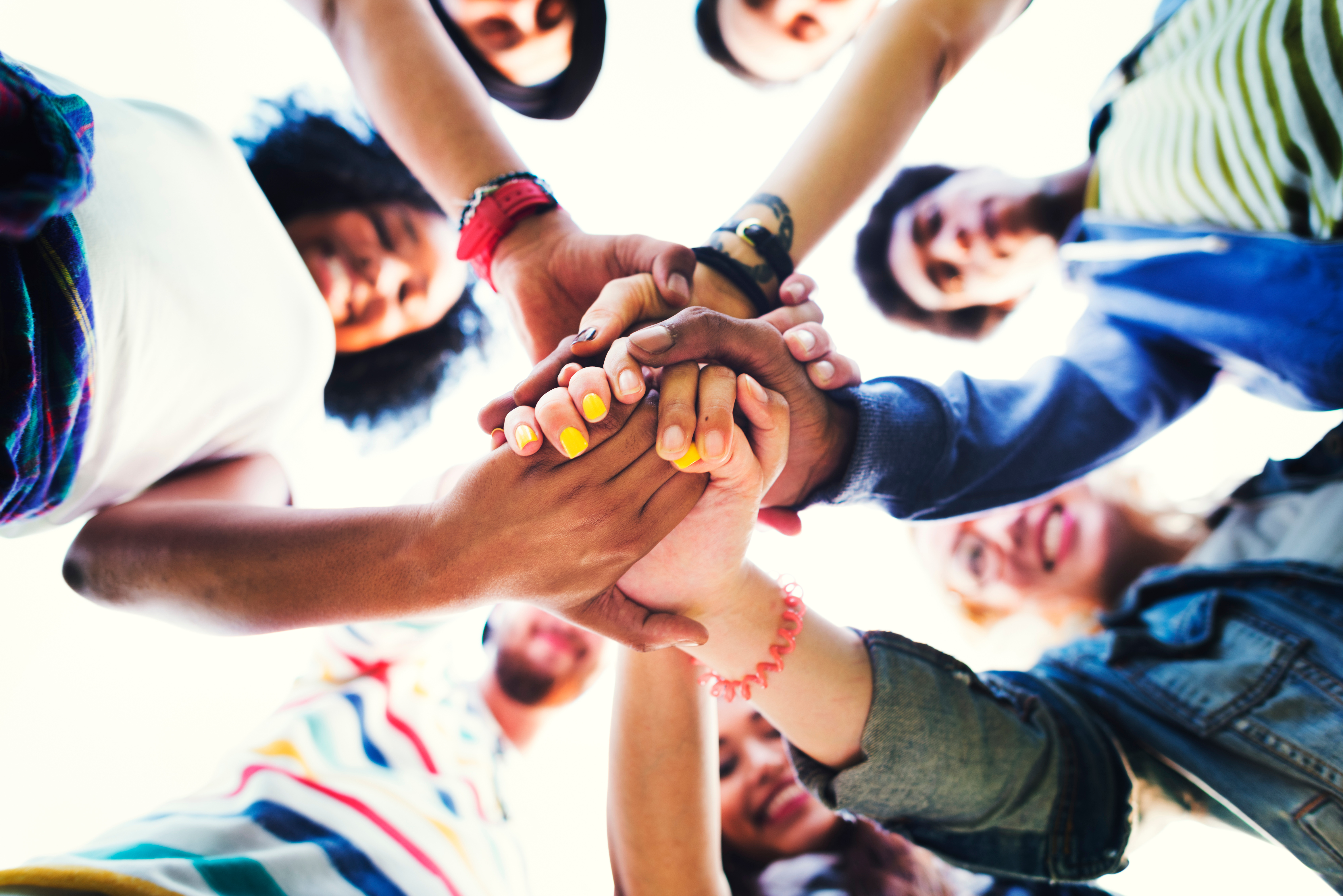 "Youth gather and place hands together in a circle"