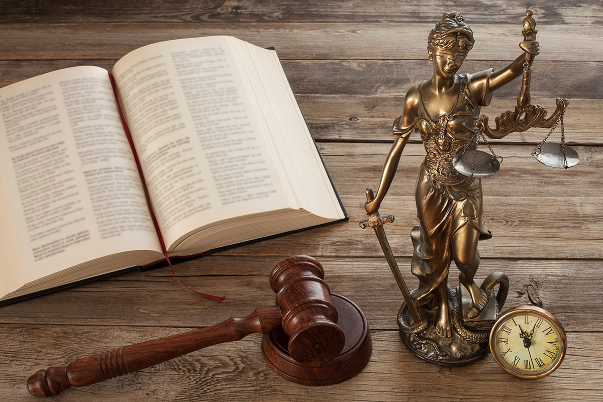 Justice figure next to a gavel and open law book.