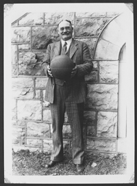 Historic photo of James Naismith holding a basketball