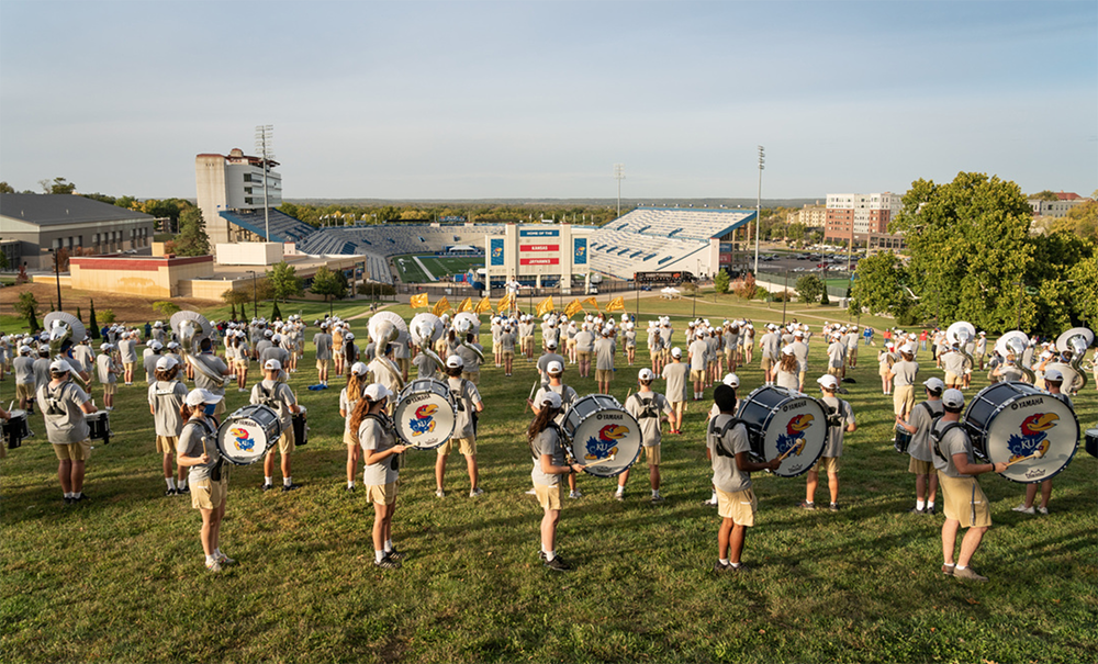 KU Marching Band on the Campanile lawn overlooking David Booth Kansas Memorial Stadium