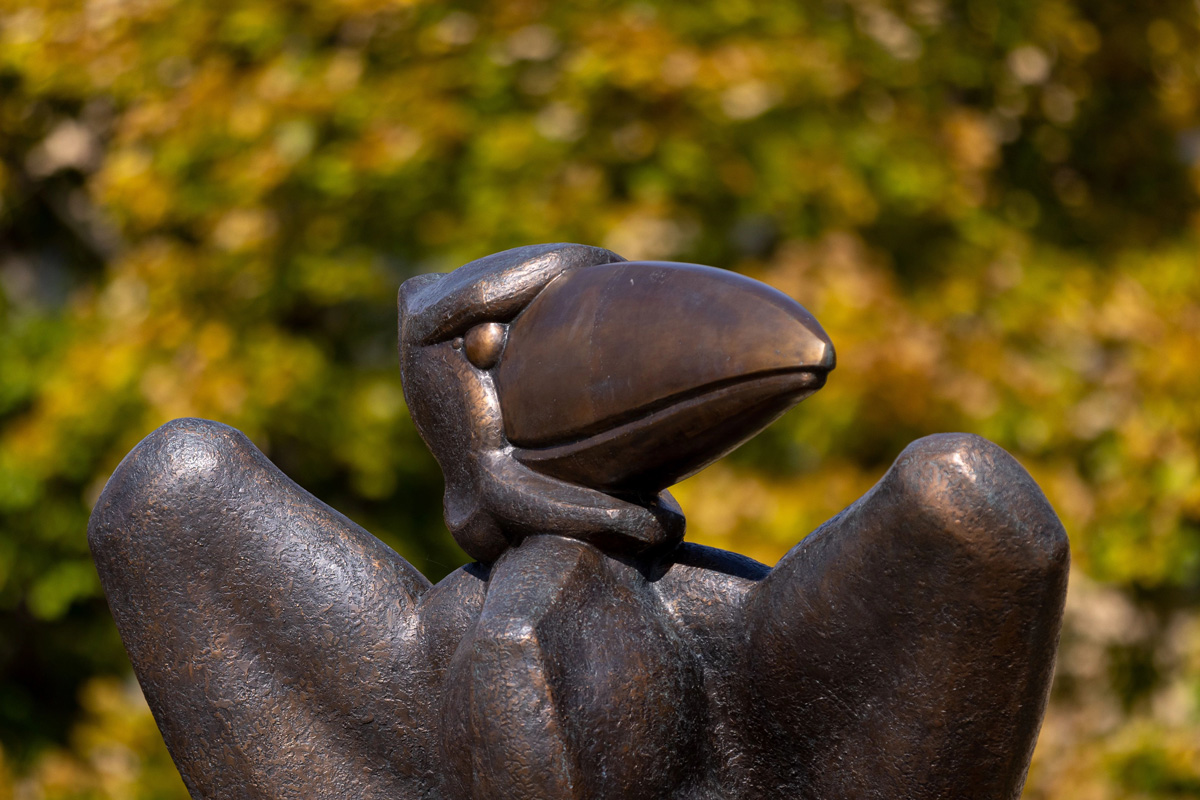 Bronze KU Jayhawk statue with fall leaves in background