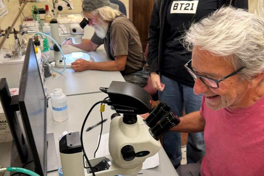 Ashley Bentz with farmer, practicing microscopy