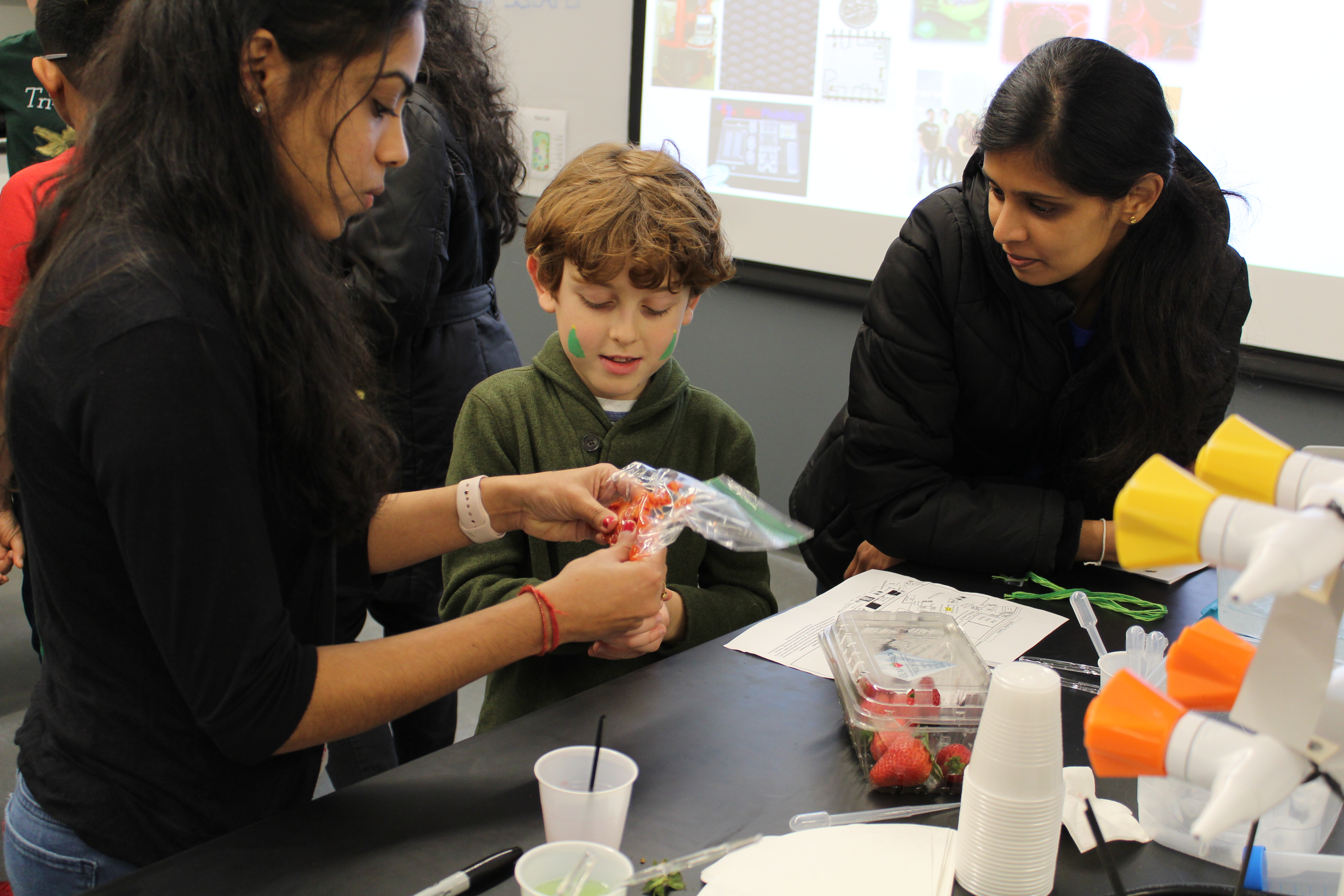 Helper holding a plastic bag demonstrating a task to a child.