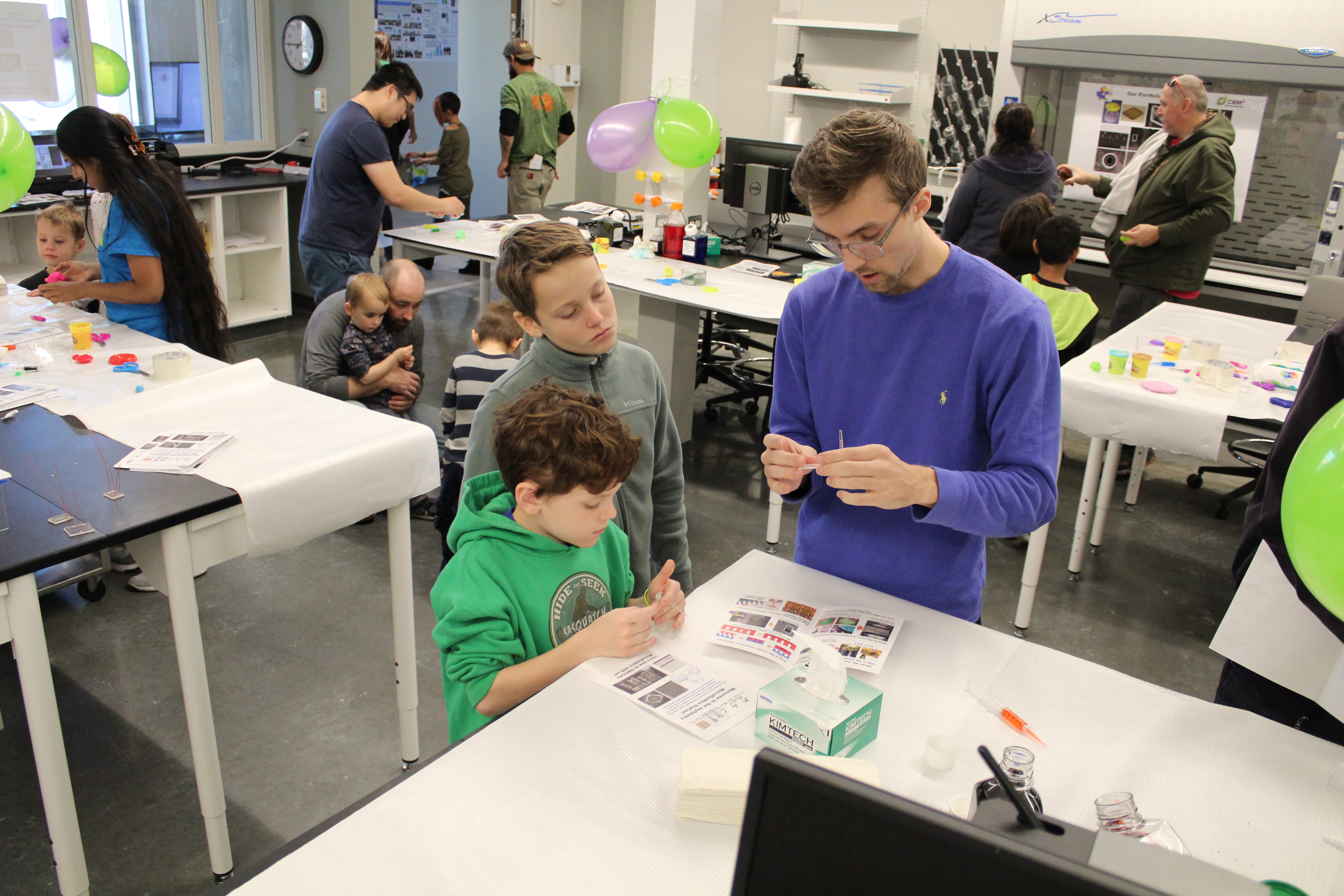 An assistant providing assistance to two children.