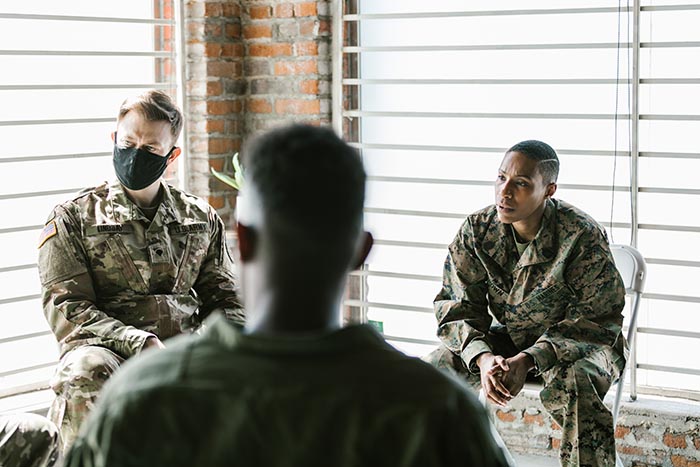 Counseling participants wearing military fatigues, masks. Credit: Pexels