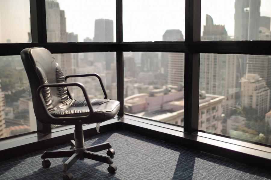 An empty chair sits overlooking the view from a corporate office.