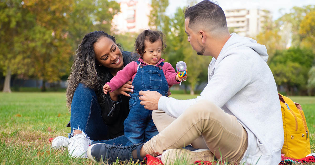 Young couple with child outdoors. Credit: Pexels