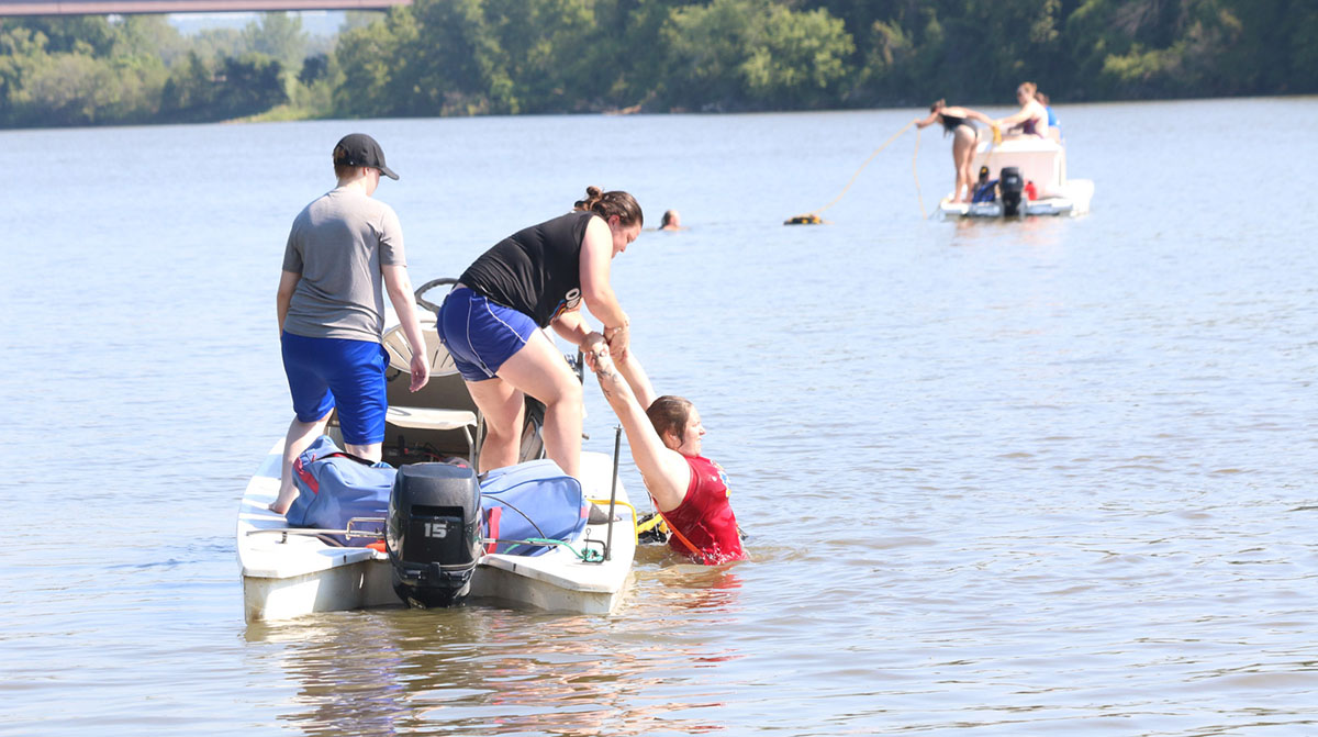 Assistant KU Rowing Coach Madison Hovis practices assisting KU Rowing Athletic Trainer Danielle Meyer out of the water.