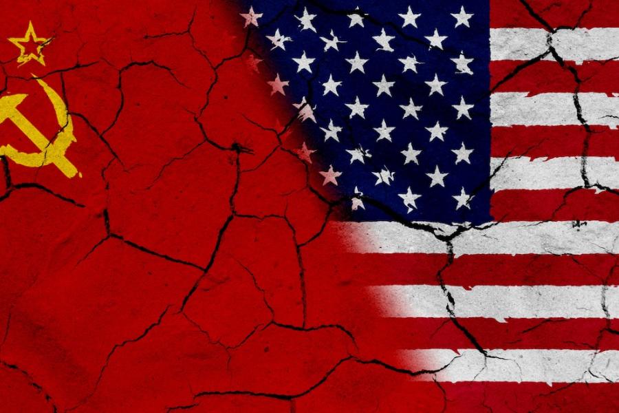 An image of a Soviet flag and American flag superimposed on cracked pavement collide.