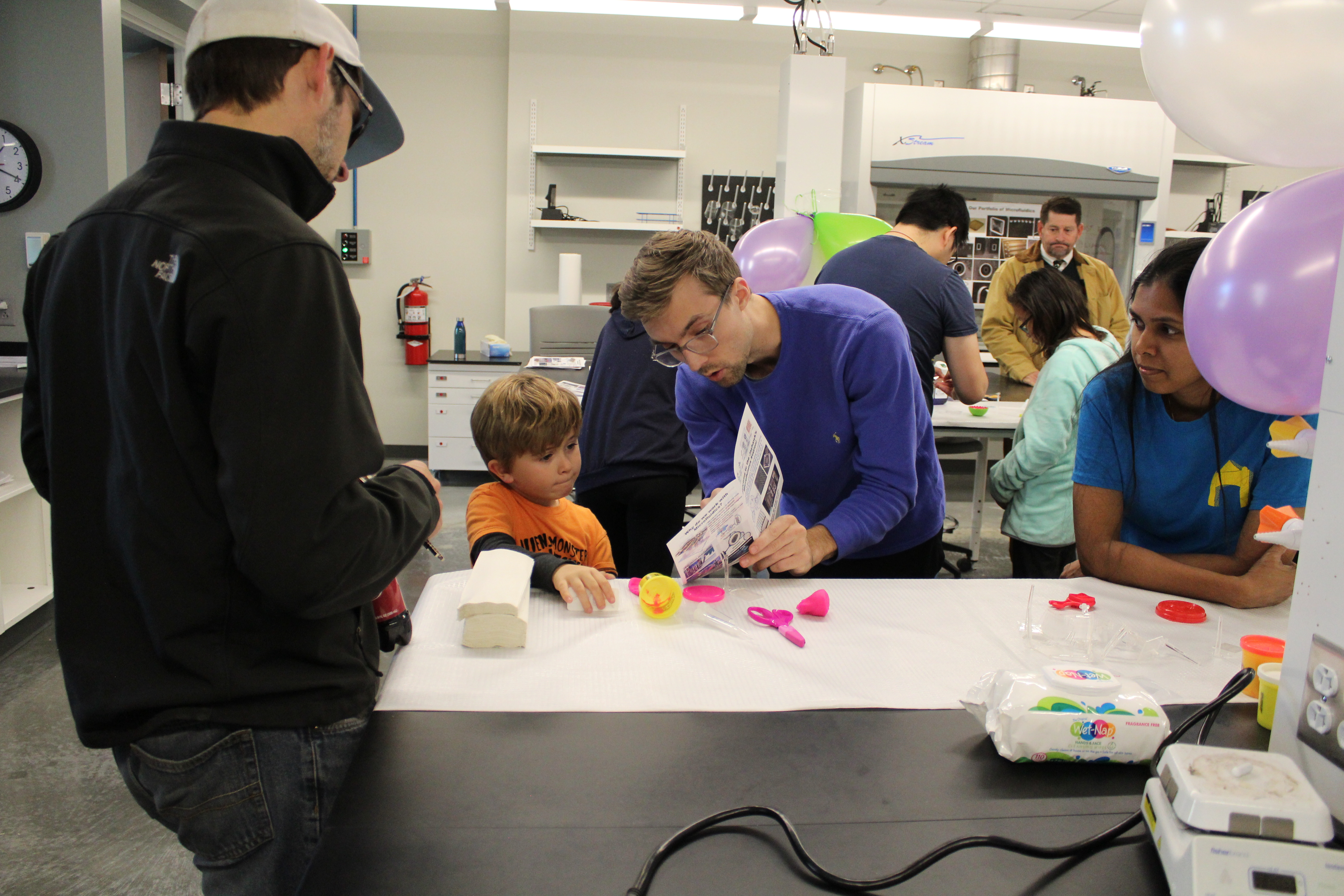 An adult showing a child how to complete a craft.