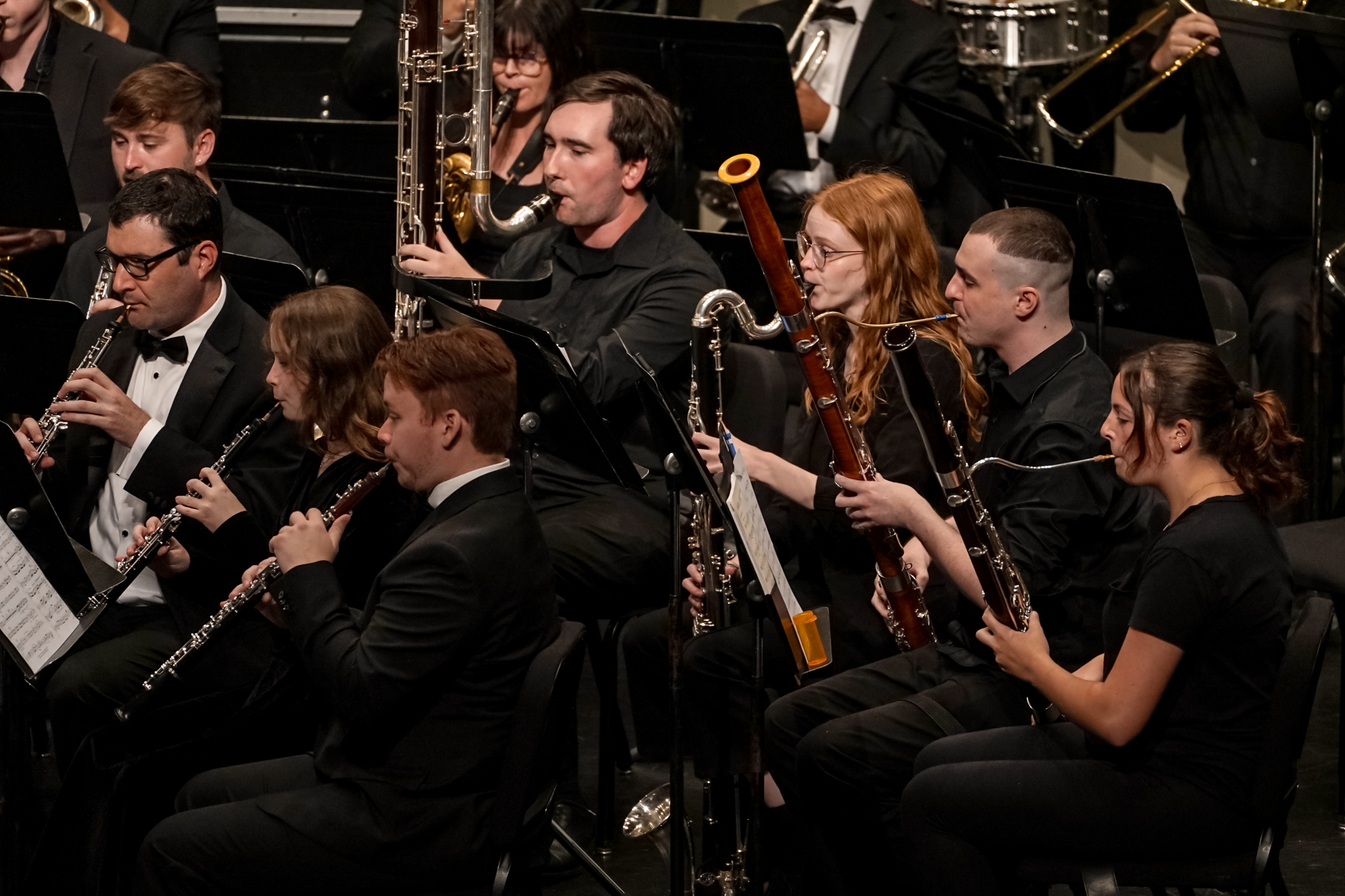 A group of students wearing black and playing instruments onstage.