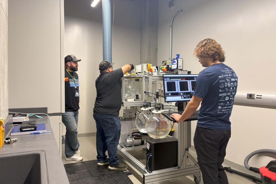 3 people setting up an experiment with monitoring equipment
